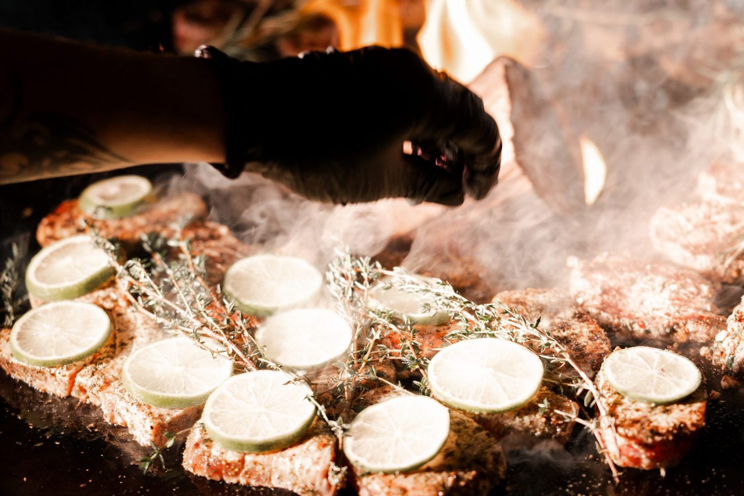 Live-Cooking auf einer Grilltonne mit Flammen